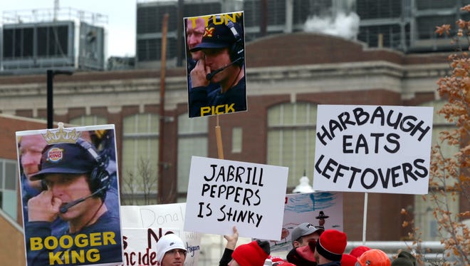Various signs held up Ohio State fans making fun of Michigan head coach Jim Harbaugh and the Wolverines during the live broadcast of ESPN "College GameDay" before the game between Michigan and Ohio State at Ohio Stadium in Columbus on Saturday, November 26, 2016.