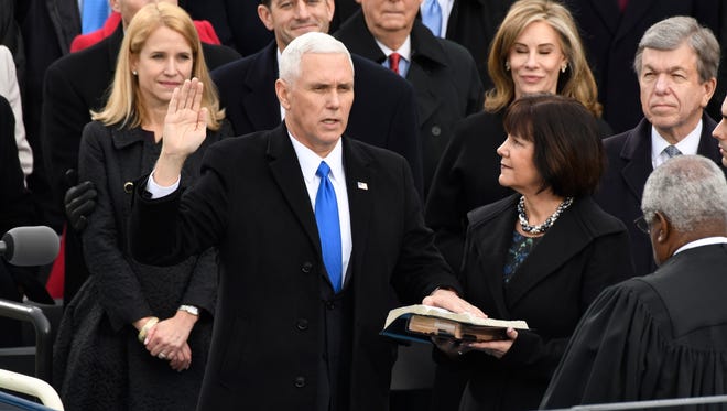 Vice President-elect Mike Pence takes the oath of office next to his wife Karen.