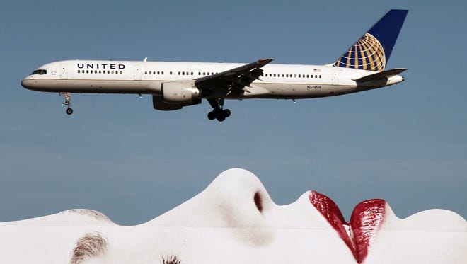 A United Airlines Boeing 757 passes a billboard on approach to Los Angeles International Airport (LAX) on Jan. 17, 2013.