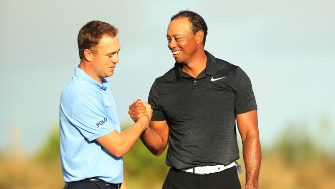 Tiger Woods shakes hands with Justin Thomas after completing their first rounds on Thursday at the Hero World Challenge in Nassau, Bahamas. Woods shot a 3-under 69.
