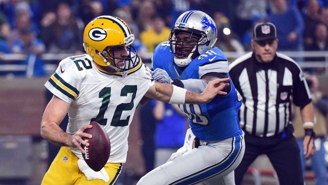 Packers quarterback Aaron Rodgers (12) scrambles as Lions defensive end Devin Taylor (98) pressures during the first quarter.