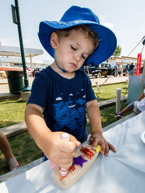 Three-year-old Logan Scheeler of Oconomowoc embellishes a toy boat during the 13th Annual Antique & Classic Boat Show at Pewaukee's Lakefront Park on Saturday, August 19, 2017. The event features vintage boats, a classic car show, vintage bicycles, live music, food and much more.