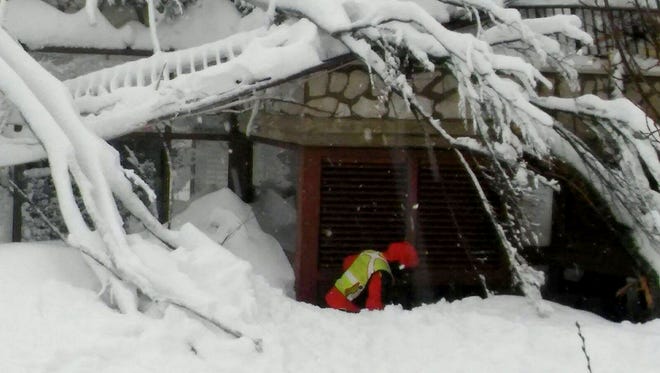 Italian National Alpine Cliff and Cave Rescue Corps members work at the hotel Rigopiano after it was hit by an avalanche in Farindola Italy Jan. 19, 2017.