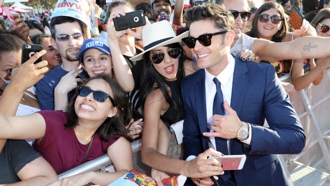 'Baywatch' ushered in swimsuit season Saturday at the movie's world premiere in Miami. Zac Efron, who stars as Matt Brody in the reboot, poses for selfies with fans in South Beach.