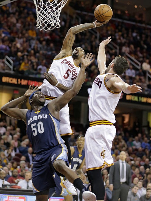 Cleveland Cavaliers' J.R. Smith (5) shoots over Memphis Grizzlies' Zach Randolph (50) in the first half of an NBA basketball game Tuesday, Dec. 13, 2016, in Cleveland. Kevin Love is on the right. (AP Photo/Tony Dejak)