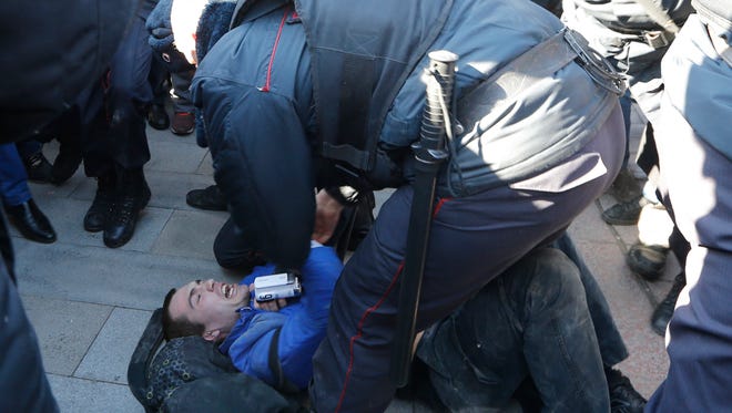 Police detain a protester in Russia.