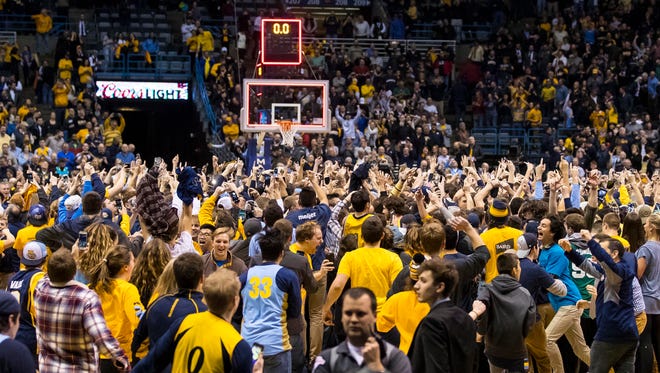 Marquette fans charge the court after the Golden Eagles stunned Villanova.