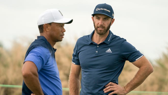 Dustin Johnson talks to Tiger Woods on the practice green during Monday's practice round of the Hero World Challenge.