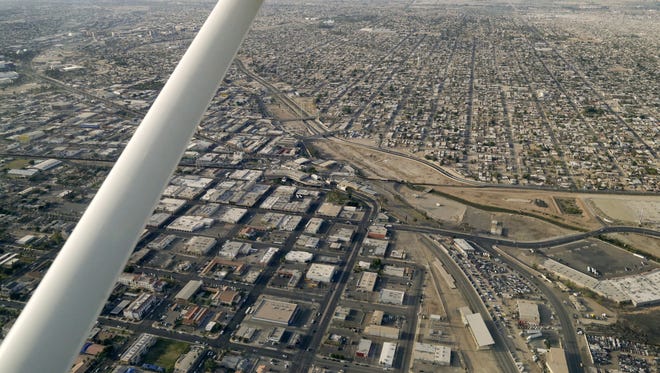 This May 1, 2015 photo shows an aerial view of the United States-Mexico border showing Calexico, California below and Mexicali, Mexico above.The U.S. Justice Department issued a scathing review May 18, 2016, of Calexico's police practices in a big drug and immigrant smuggling corridor on California's border with Mexico. The Justice Department found a lack of basic controls and oversight of criminal investigations, unstable leadership and other red flags.