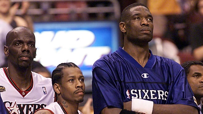 Allen Iverson stands with teammates Tyrone Hill and Dikembe Mutombo, showing a huge height difference.
