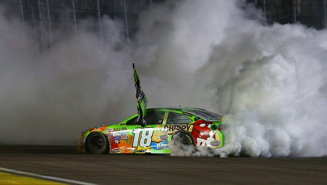 Busch celebrates with a burnout after clinching the 2015 Sprint Cup title with a victory in the season-ending Ford EcoBoost 400 at Homestead-Miami Speedway.