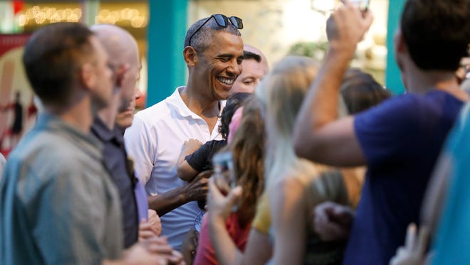 Obama greets people waiting for him outside Island Snow Hawaii in Kailua, Hawaii, on Dec. 24, 2016, after the president, joined by family and friends, had shave ice during the first family's annual vacation.