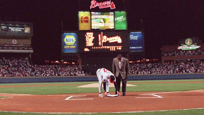 Hank Aaron looks on as pitcher Tom Glavine puts home plate from Atlanta Fulton County Stadium on top of the plate at Turner Field before the first game at Turner Field on April 4, 1997.
