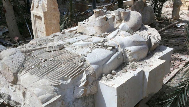 A destroyed statue outside the damaged Palmyra Museum, in Palmyra city, central Syria.