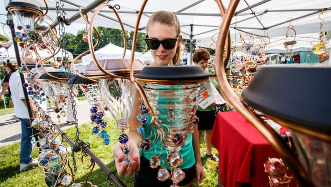 Megan Giesie of Wales shops at the JLE Designs booth during the Donna Lexa Memorial Art Fair in Wales on Saturday, Aug. 19, 2017. The annual event features arts and crafts, food, children's activities, live entertainment and more.