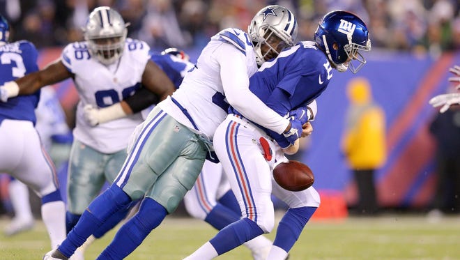 Giants quarterback Eli Manning (10) fumbles as he is hit by Cowboys defensive end Benson Mayowa (93) during the second quarter.