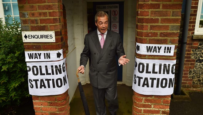 UK Independence Party leader Nigel Farage poses for photographers as he leaves a polling station south of London as Britain holds a referendum to vote on whether to remain in or to leave the European Union.