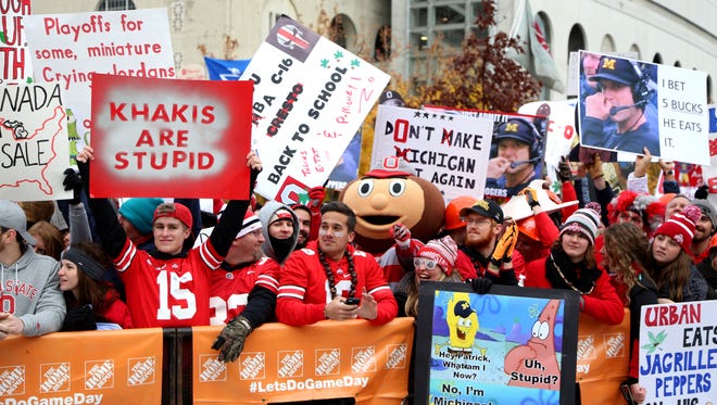 Various signs held up Ohio State fans making fun of Michigan head coach Jim Harbaugh and the Wolverines during the live broadcast of ESPN "College GameDay" before the game between Michigan and Ohio State at Ohio Stadium in Columbus on Saturday, November 26, 2016.