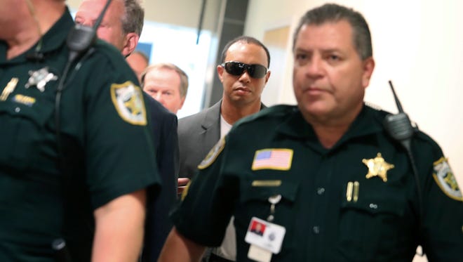 Tiger Woods makes his way into a North County Courthouse courtroom.