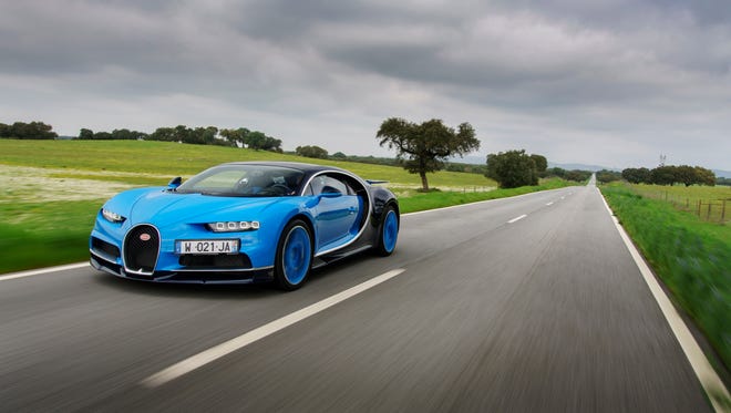 A Bugatti Chiron driving down a country road.