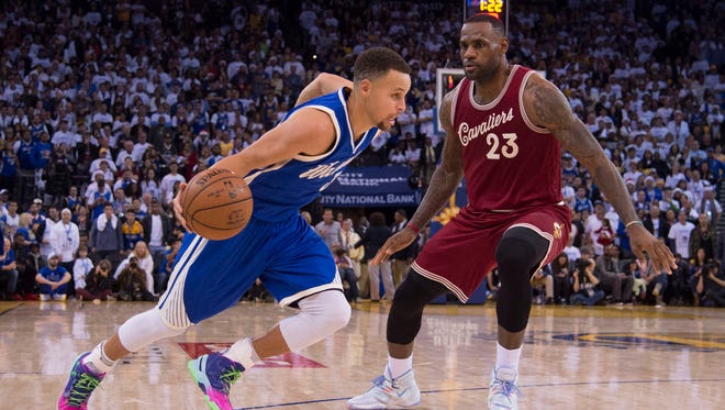 Golden State Warriors guard Stephen Curry dribbles the basketball against Cleveland Cavaliers forward LeBron James in the fourth quarter of a NBA basketball game on Christmas at Oracle Arena.