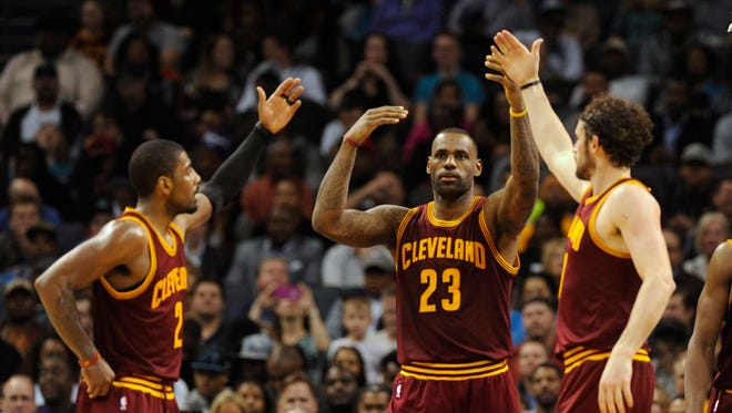Cleveland Cavaliers forward LeBron James (23) gets a high five from his teammates guard Kyrie Irving (2) and forward Kevin Love (0) in a recent game.