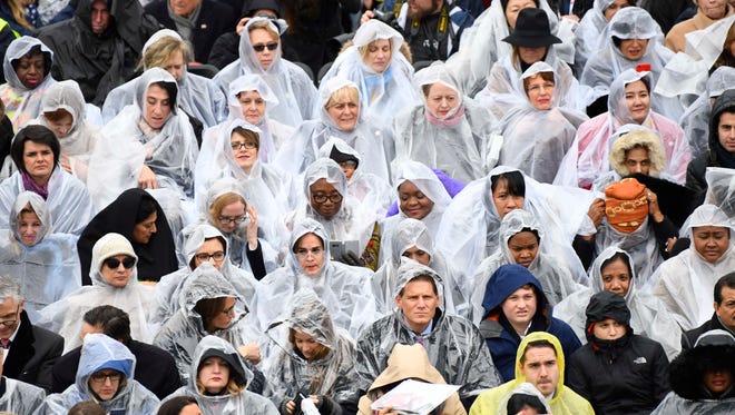 Attendees cover themselves from rain during the 2017 Presidential Inauguration.