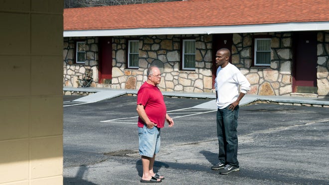 Alex Abrahams, right, owner of the Red Carpet Inn, talks with the Inn's property manager James Bangs.