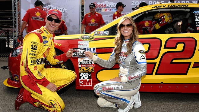 Joey Logano poses with the Coors Light Pole Award and Miss Coors Light Rachel Rupert after qualifying for pole position for the NASCAR Sprint Cup Series 44th Annual Pure Michigan 400 at Michigan International Speedway on August 16, 2013.