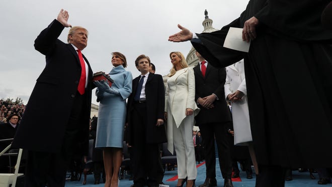 U.S. President Donald Trump takes the oath of office as his wife Melania holds the bible and his children Barron, Ivanka, Eric and Tiffany watch.