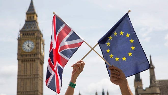 Members of the public hold flags at a stay-in, pro-EU Referendum event in Parliament Square in London on June 19, 2016.