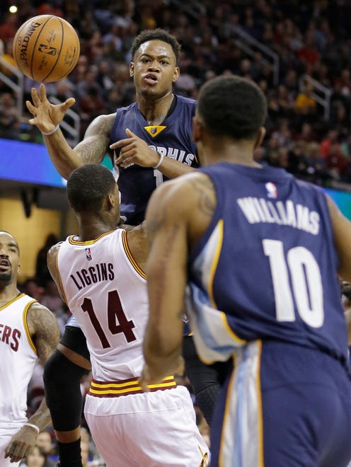 Memphis Grizzlies' Jarell Martin (1) passes over Cleveland Cavaliers' DeAndre Liggins (14) to Troy Williams (10) in the second half of an NBA basketball game Tuesday, Dec. 13, 2016, in Cleveland. The Cavaliers won 103-86. (AP Photo/Tony Dejak)