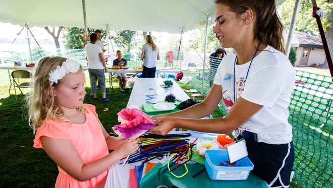 Volunteer Sophie Tesch helps seven-year-old Taylor Hooper of Oconomowoc with her art project in the children's tent at the 47th annual Oconomowoc Festival of the Arts in Fowler Park on Saturday, August 19, 2017.