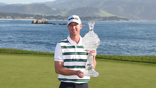 Vaughn Taylor hoists the trophy after winning the AT&T Pebble Beach National Pro-Am at Pebble Beach Golf Links on Feb. 14, 2016.