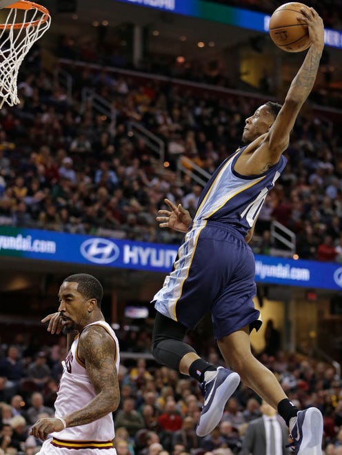 Memphis Grizzlies' Troy Williams, right, dunks the ball over Cleveland Cavaliers' J.R. Smith in the second half of an NBA basketball game, Tuesday, Dec. 13, 2016, in Cleveland. The Cavaliers won 103-86. (AP Photo/Tony Dejak)