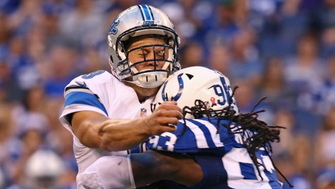 Detroit Lions quarterback Matthew Stafford is hit by Indianapolis Colts outside linebacker Erik Walden (93) as he fires a touchdown pass.