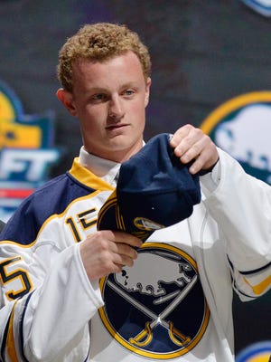Jack Eichel puts on a Buffalo Sabres cap after being selected with the No. 2 pick in the NHL draft.