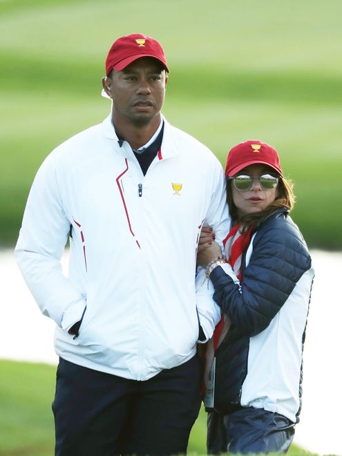 Tiger Woods and Erica Herman look on during Saturday four-ball matches of the Presidents Cup at Liberty National Golf Club on Sept. 30.