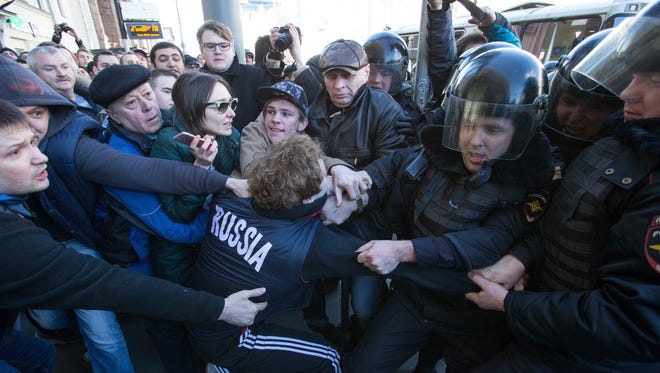 Police detain a protester in downtown Moscow.  The protests appeared to be one of the largest coordinated outpourings of dissatisfaction in Russia since the massive 2011-12 demonstrations that followed a fraud-tainted parliamentary election.