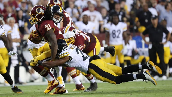 Redskins running back Matt Jones (31) tries to elude Steelers defender Mike Mitchell (23) on a first-half carry.