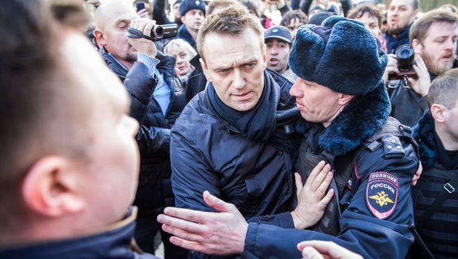 In this photo provided by Evgeny Feldman, Alexei Navalny is detained by police in Moscow on March 26, 2017. Alexei Navalny is an anti-corruption campaigner who is leading the opposition to President Vladimir Putin. 
Navalny and his Foundation for Fighting Corruption had called for the protests, which attracted crowds of hundreds or thousands in most sizable Russian cities, from the Far East port of Vladivostok to the European heartland.