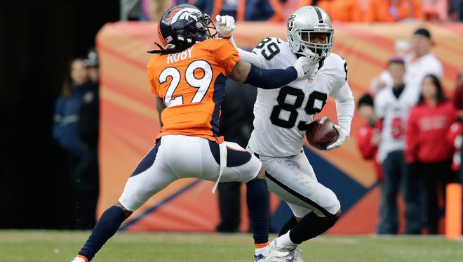 Broncos cornerback Bradley Roby (29) pushes Raiders wide receiver Amari Cooper (89) out of bounds in the second quarter.