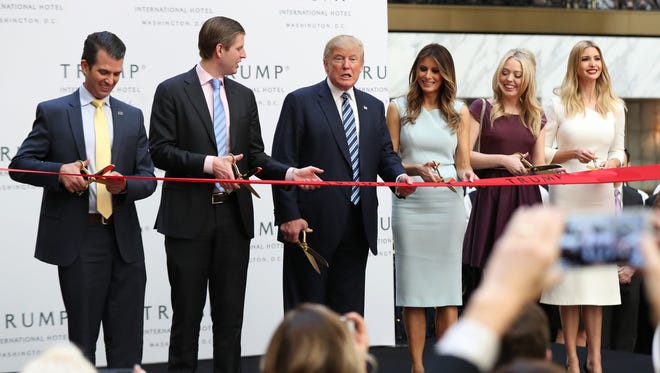 Donald Trump, together with his family, from left, Donald Trump Jr., Eric Trump, Melania Trump, Tiffany Trump and Ivanka Trump, speaks in the hotel lobby during the grand opening of Trump International Hotel in Washington on Oct. 26, 2016.