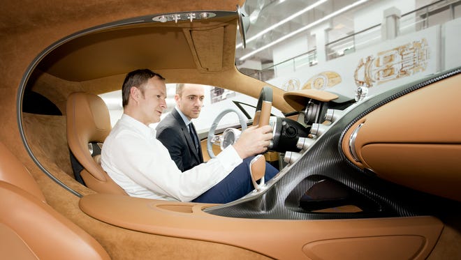 Bugatti Executives examine the interior cabin or the Bugatti Chiron.