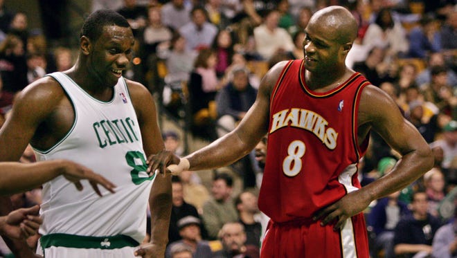2005: Antoine Walker admires his former jersey while joking with Boston Celtics rookie forward Al Jefferson.