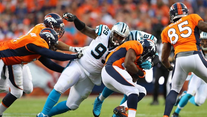 Carolina Panthers defensive tackle Kawann Short (99) tackles Denver Broncos running back C.J. Anderson.