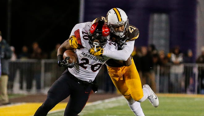 San Diego State running back Rashaad Penny is tackled by Wyoming cornerback Antonio Hull during the Mountain West Championship Game at War Memorial Stadium in Laramie, Wyo.
