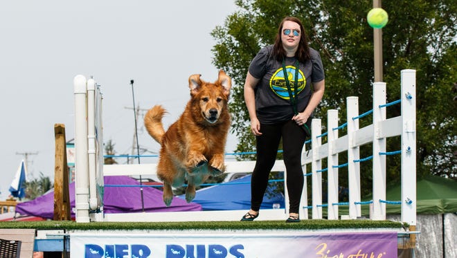 Sarah Kowalske of Delafield throws a tennis ball for her dog during the Pier Pups canine dock jumping competition hosted by Petlicious Dog Bakery in Pewaukee on Sunday, Aug. 20, 2017.