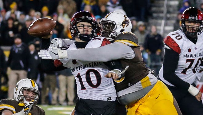 San Diego State quarterback Christian Chapman (10) is hit by Wyoming defensive tackle Youhanna Ghaifan (93) during the fourth quarter of the Mountain West title game.