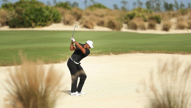 Tiger Woods of the United States plays out of a fairway bunker on the par-five sixth hole during the first round of the Hero World Challenge in Nassau, Bahamas.  Woods made par.